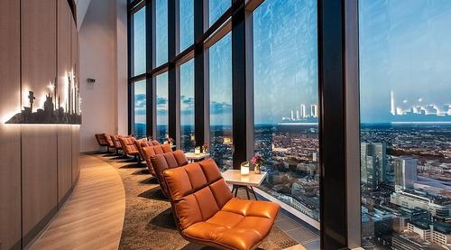 Ein hochmodernes Loungebereich mit Panoramafenstern, die einen beeindruckenden city-Blick bieten, und eleganten Ledersesseln.